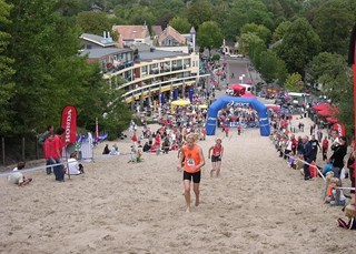 Zwoegend door het zand het klimduin op