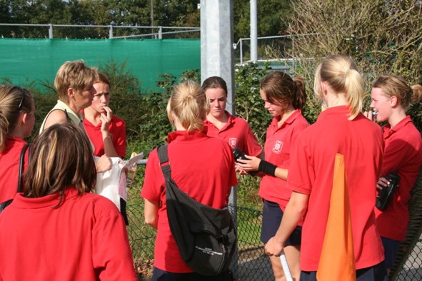 Coach Anneke geeft haar meiden aanwijzingen